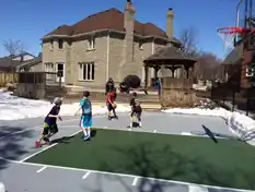 Parents watching kids playing at their backyard basketball court